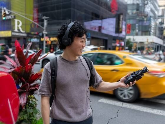 Mann mit Kopfhörern und Audiorekorder an einer belebten Straße